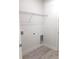 A simple laundry room design with white walls, wire shelving, and light-colored floors at 12793 Sw 43Rd Cir, Ocala, FL 34473