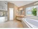 Spacious bathroom with dual sinks, shower, garden tub, and a view of the outdoor patio and lawn at 1306 Pleasantridge Pl, Orlando, FL 32835