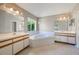 Bright bathroom with dual sinks, vanities, and a large garden tub next to a big window at 1306 Pleasantridge Pl, Orlando, FL 32835