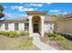 Home with manicured lawn, flowers, arched entryway, and many windows allowing ample sunlight at 1306 Pleasantridge Pl, Orlando, FL 32835