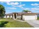 Well-maintained one-story home with lush lawn, arched entryway, and two-car garage at 1306 Pleasantridge Pl, Orlando, FL 32835