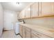 Functional laundry room with washer, dryer, tile floor, white cabinets and counter space at 1306 Pleasantridge Pl, Orlando, FL 32835