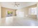 Bright living room featuring neutral walls, tile flooring, ceiling fan, and sliding door access to the screened porch at 1306 Pleasantridge Pl, Orlando, FL 32835