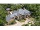 Aerial view of a stunning brick home with a gray tile roof, pool, patio, and lush landscaping at 1500 Whitstable Ct, Lake Mary, FL 32746
