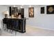 Stylish bar area featuring black cabinets with gold trim and seating for four at 1500 Whitstable Ct, Lake Mary, FL 32746