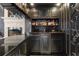 Wet bar with black and gold finishes, granite countertops and a wine fridge at 1500 Whitstable Ct, Lake Mary, FL 32746