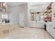 Large bathroom with soaking tub, white vanity, and travertine tile at 1500 Whitstable Ct, Lake Mary, FL 32746