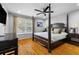 Elegant bedroom features a dark wood four-poster bed, hardwood floors, and side tables at 1500 Whitstable Ct, Lake Mary, FL 32746