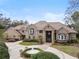 Stunning exterior of the home with a circular driveway and manicured landscaping at 1500 Whitstable Ct, Lake Mary, FL 32746