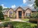 Beautiful home showcasing a brick facade with an arched doorway and manicured landscaping at 1500 Whitstable Ct, Lake Mary, FL 32746