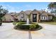 Elegant brick home with a circular driveway, lush landscaping, and a beautiful fountain feature in the front yard at 1500 Whitstable Ct, Lake Mary, FL 32746