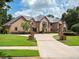 Charming brick home with a tile roof, manicured lawn, and circular driveway at 1500 Whitstable Ct, Lake Mary, FL 32746