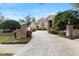 Charming brick home with lush landscaping and a circular driveway, featuring elegant brick pillars and decorative lanterns at 1500 Whitstable Ct, Lake Mary, FL 32746