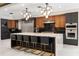 Gourmet kitchen with marble island, black countertops, and sleek stainless steel appliances at 1500 Whitstable Ct, Lake Mary, FL 32746