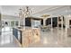 Open concept kitchen and dining room with large island, stone floors, and abundant natural light at 1500 Whitstable Ct, Lake Mary, FL 32746