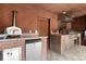 Inviting outdoor kitchen featuring stone counters, pizza oven, grill, mini-fridge, and hood at 1500 Whitstable Ct, Lake Mary, FL 32746