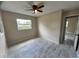 Cozy bedroom featuring tile flooring, neutral walls, and a view of the yard through the window at 1511 Leeway Ave, Orlando, FL 32810