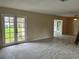 Bright living room featuring neutral walls, tile flooring, and French doors leading to the yard at 1511 Leeway Ave, Orlando, FL 32810