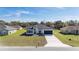 Aerial view of a single-story home showcasing a well-manicured lawn and a modern exterior design with a two-car garage at 15499 Sw 48Th Ave, Ocala, FL 34473
