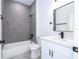 Bathroom featuring gray-tiled shower/tub, white vanity with quartz countertop, and modern black fixtures at 15499 Sw 48Th Ave, Ocala, FL 34473