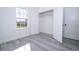 Bright bedroom with a window, closet, and gray wood-look flooring at 15499 Sw 48Th Ave, Ocala, FL 34473