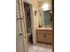 Cozy bathroom with a sink, toilet, shelving, and neutral tile floors at 1663 Sunburst Way, Kissimmee, FL 34744