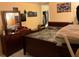 Bedroom featuring a large bed with a dresser, mirror, and personal touches at 1663 Sunburst Way, Kissimmee, FL 34744