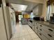 Bright kitchen with tile flooring, light cabinets, and garden view from adjacent dining area at 1663 Sunburst Way, Kissimmee, FL 34744