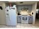 This cozy kitchen features a modern white refrigerator and stylish grey cabinetry at 1663 Sunburst Way, Kissimmee, FL 34744