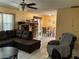 Cozy living room with tile floors, ceiling fan, and comfortable brown sectional sofa at 1663 Sunburst Way, Kissimmee, FL 34744