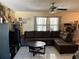 Comfortable living room with a large sectional sofa, ceiling fan, and tile flooring at 1663 Sunburst Way, Kissimmee, FL 34744