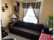 Cozy living room featuring a comfortable sofa and natural light from the window at 1663 Sunburst Way, Kissimmee, FL 34744