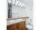 Bathroom featuring a large mirror, vanity with wood cabinets and a tub with shower at 1695 Lee Rd # E205, Winter Park, FL 32789