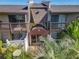 Inviting townhouse exterior featuring a covered entryway and balcony overlooking lush greenery at 1695 Lee Rd # E205, Winter Park, FL 32789