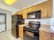 A close up on the kitchen appliances, wood cabinets, and view of in-unit laundry at 1695 Lee Rd # E205, Winter Park, FL 32789