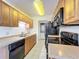 Efficient kitchen featuring wood cabinets, black appliances, and tile flooring for easy maintenance at 1695 Lee Rd # E205, Winter Park, FL 32789