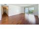 Open-concept living room with wood floors and a sliding glass door leading to an outdoor balcony at 1695 Lee Rd # E205, Winter Park, FL 32789