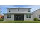 The back of a two-story home features a screened in porch and solar panels at 18410 Blue Heron Cir, Deer Island, FL 32778