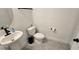 Modern powder bathroom featuring pedestal sink, black fixtures and tile floor at 18410 Blue Heron Cir, Deer Island, FL 32778