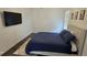 Bedroom with bed, dark floors, tv, and white walls at 18410 Blue Heron Cir, Deer Island, FL 32778