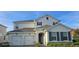 Elegant home featuring a stucco facade, gray shutters, a two-car garage, and an inviting front entrance at 18410 Blue Heron Cir, Deer Island, FL 32778