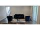 Bright living room featuring dark floors, a modern couch, chairs, and a sliding glass door at 18410 Blue Heron Cir, Deer Island, FL 32778