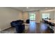 Bright living room featuring dark floors, a modern couch, chairs, and a sliding glass door at 18410 Blue Heron Cir, Deer Island, FL 32778