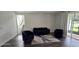 Bright living room featuring dark floors, a modern couch, chairs, and a sliding glass door at 18410 Blue Heron Cir, Deer Island, FL 32778