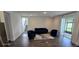 Bright living room featuring dark floors, a modern couch, chairs, and a sliding glass door at 18410 Blue Heron Cir, Deer Island, FL 32778