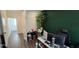 Well-lit office space featuring modern decor, a large plant, and dark green accent wall at 18410 Blue Heron Cir, Deer Island, FL 32778