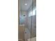 Modern glass-enclosed shower with white marble-look tile and a window at 18410 Blue Heron Cir, Deer Island, FL 32778