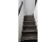 Wooden staircase with a white wall and black handrail at 18410 Blue Heron Cir, Deer Island, FL 32778