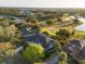 Aerial view of property showcasing manicured lawn, mature trees, and access to a golf course at 2207 Cairns Ct, Orlando, FL 32835