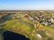 Aerial view showcases a neighborhood near a golf course with a tranquil lake at 2207 Cairns Ct, Orlando, FL 32835